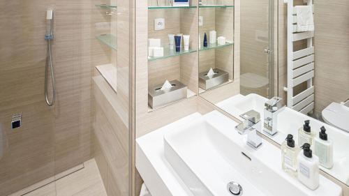 a bathroom with a sink and a shower at HOTEL Hraniční zámeček in Hlohovec