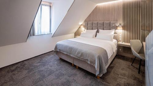 a bedroom with a large bed and a window at HOTEL Hraniční zámeček in Hlohovec