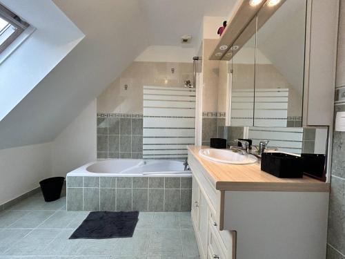 une salle de bain avec une baignoire et un lavabo dans l'établissement 956 - Maison 6p, à 15min du Val-André et d'Erquy., à Hénansal