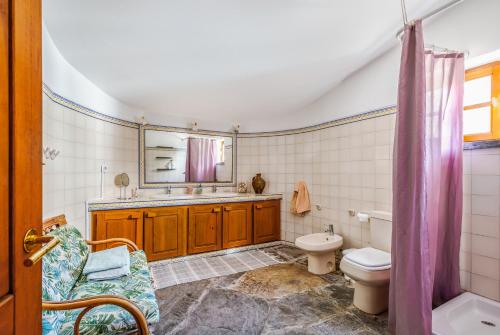 a bathroom with a sink toilet and a mirror at Casa do Mar in Sesimbra