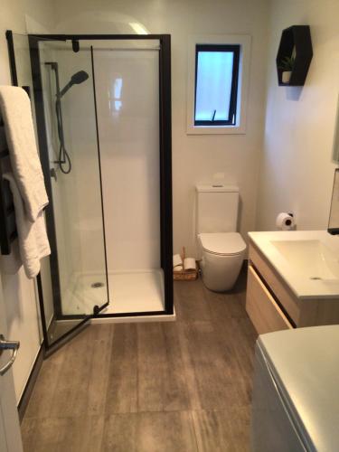 ein Bad mit einer Dusche und einem WC in der Unterkunft Black Beauty - Double Family Lake House for 12 with a NEW SPA & Pets in Mangakino
