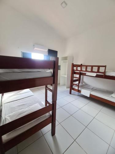 two bunk beds in a room with a tiled floor at Pousada Marinha do Céu Maceio in Maceió
