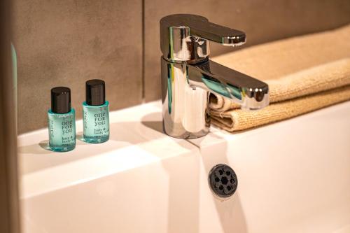 un lavabo con dos botellas de odorizantes. en Historical building Brody Apartment en Budapest