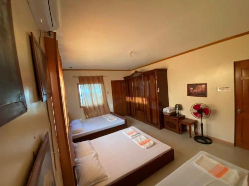 a small room with two beds and a window at The Orange House - Vigan Villa in Vigan