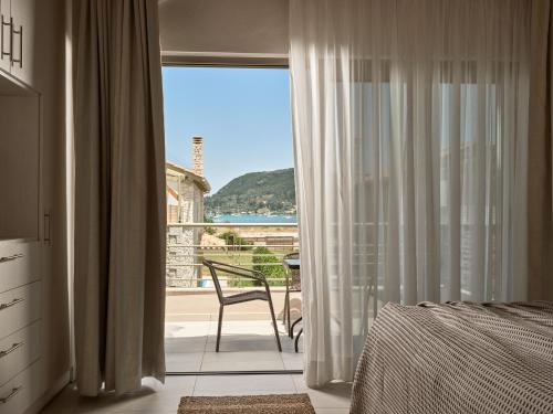 a bedroom with a window with a view of the ocean at Avesta Private Villas - Iokasti in Vlikhon
