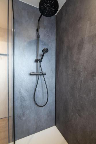 a shower with a shower head on a wall at K1, appartement avec grande terrasse et vue pistes in Gérardmer