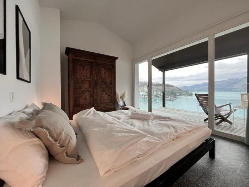 a bedroom with a bed with a view of the water at Wohnung mit grossartiger Seesicht und Balkon in Spiez