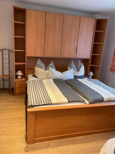 a bed with a large wooden headboard and pillows at Ferienwohnung Mitko in Radebeul