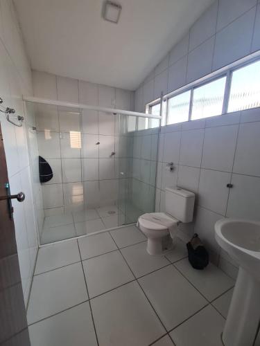 a white bathroom with a toilet and a sink at Pousada Marinha do Céu Maceio in Maceió