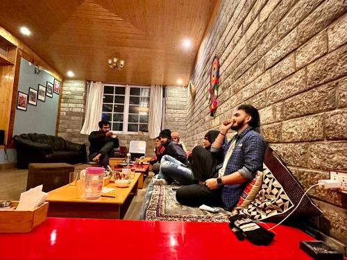 a group of men sitting in a room talking on their cell phones at Flüstern Manali in Nagar