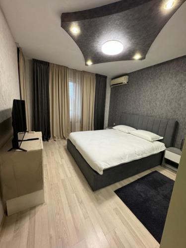 um quarto com uma cama e uma televisão em Апартамент БМ em Vratsa