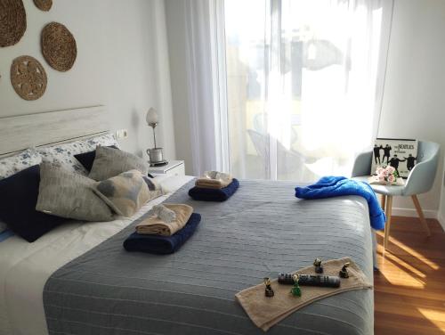 a bedroom with a large bed with towels on it at Apartamento Morriña in Brion