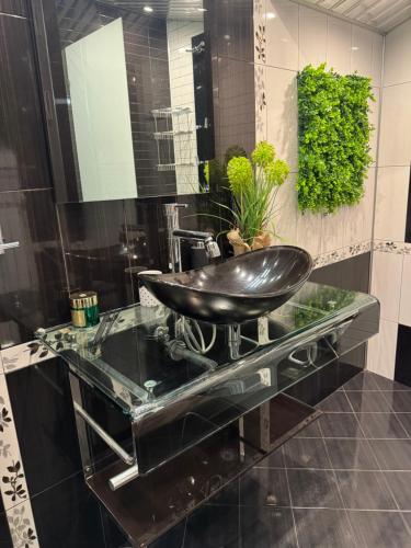 a bathroom with a black sink on a glass counter at Апартамент БМ in Vratsa