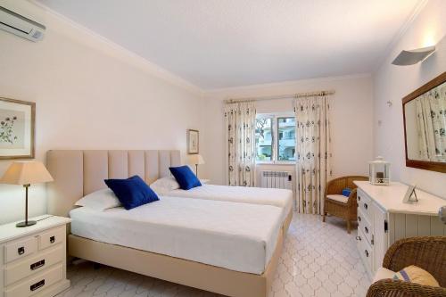 een slaapkamer met 2 bedden en blauwe kussens bij Bia in Almancil
