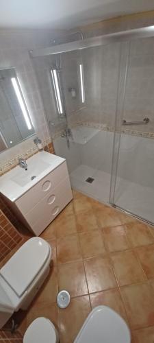 een badkamer met een douche, een wastafel en een toilet bij Apartamento Torreón del Mar 100m de la playa garage in Benalmádena