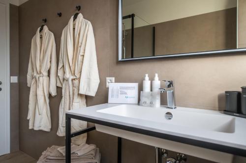 ein Badezimmer mit einem weißen Waschbecken und einem Spiegel in der Unterkunft RELAX Ortensia Apartment in Locarno