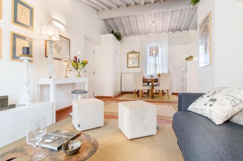 een woonkamer met een bank en een tafel bij Casa Santa Zita, A Toproof Penthouse Apartment with Elevator and Private Garden Inside the Walls in Lucca
