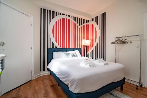 um quarto com uma cama grande e um coração na parede em French design Luxurious Downtown 3br/2ba that sleeps 8 guests with Optional Valet Parking em Chicago