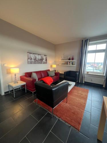 a living room with a red couch and a red rug at Villa Josephine App. 14 in Kühlungsborn