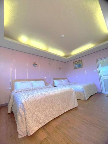 two beds in a room with pink walls at Emmanuel Farm House in Renai