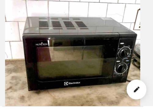 a black toaster oven sitting on top of a counter at Suite with an airy rooms in Kānpur