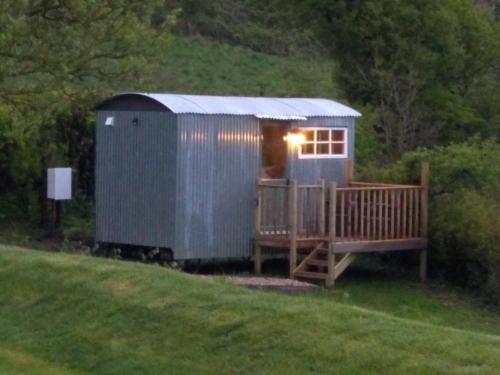 a tiny house with a porch and a deck at Shepherds hut in Weymouth