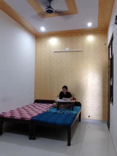 Ein Mann auf einem Bett in einem Zimmer in der Unterkunft Daughter's Home in Jaipur