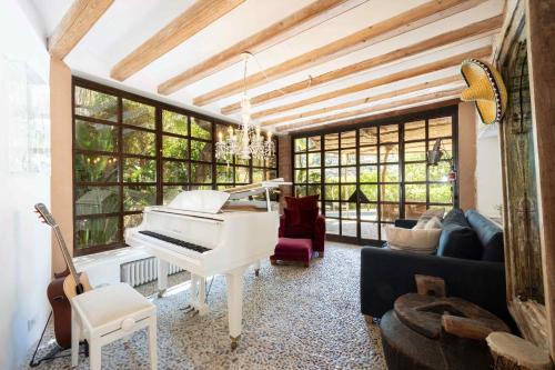 a living room with a white piano and a couch at ES CLOT in Deia