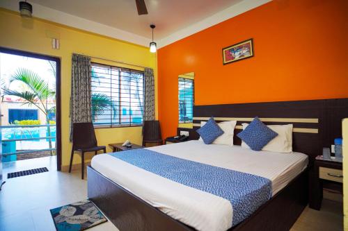 a bedroom with a large bed with an orange wall at Aqua Marina Drive Inn in Mandarmoni