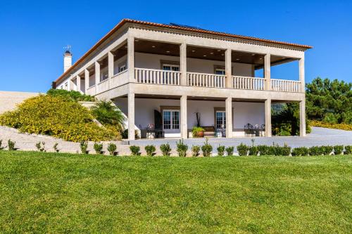 a large white house with a lighthouse on a hill at Hotel Cotto do Gatto in Ponte da Barca