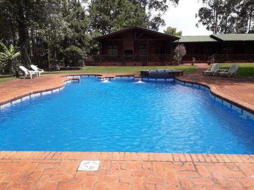 uma grande piscina com água azul num quintal em Toucan Lodge em Puerto Iguazú