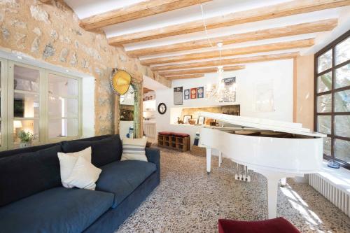 a living room with a couch and a white piano at ES CLOT in Deia