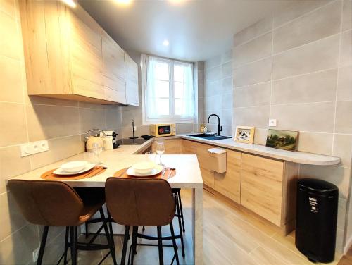 une petite cuisine avec une table et des chaises. dans l'établissement Le Cocon Design - Gare / Centre ville de Caen, à Caen