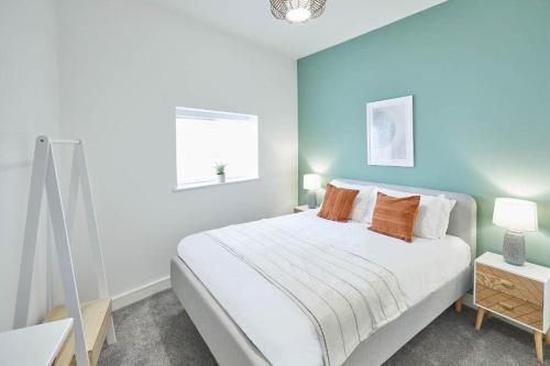 a bedroom with a white bed and a blue wall at Luxury 2 Bedroom Fully Loaded Apartment in Redcar