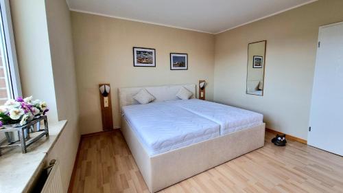- une chambre avec un lit blanc dans l'établissement "Ferienresidenz Kormoran" Appartement KOR28, à Döse