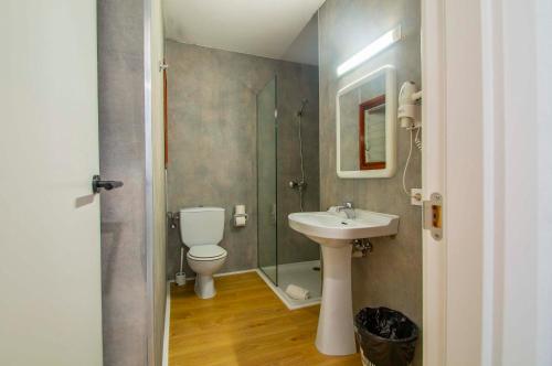 een badkamer met een toilet, een wastafel en een douche bij Apartamentos Sol y Mar II in Cala en Blanes