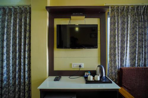 a room with a table with a tv on the wall at Aqua Marina Drive Inn in Mandarmoni