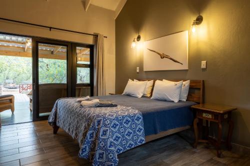 a bedroom with a bed and a sliding glass door at Africa House in Hoedspruit