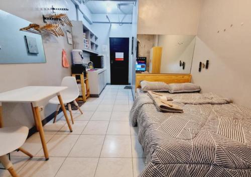 two beds in a room with a table and a kitchen at Small Apartment Near SM North Project 7 in Manila