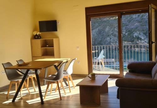 sala de estar con mesa, sillas y sofá en Apartamentos La Era de Pasé, en Sopeira