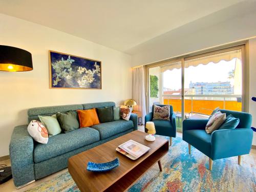 un salon avec un canapé bleu et deux chaises dans l'établissement Le Verdi By SCLS Locations, à Cannes