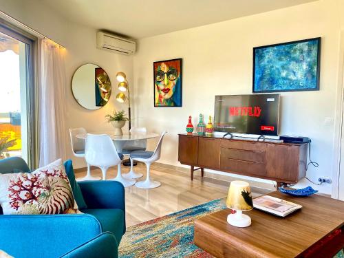 un salon avec un canapé bleu et une télévision dans l'établissement Le Verdi By SCLS Locations, à Cannes