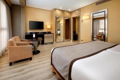a hotel room with a bed and a chair at HCC St. Moritz in Barcelona