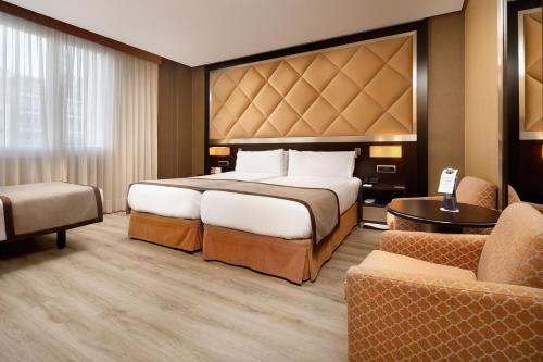 a hotel room with a large bed and a couch at HCC St. Moritz in Barcelona