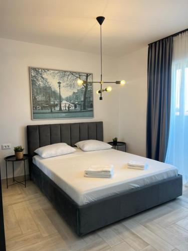 a bedroom with a large bed with two towels on it at Sunny Apartments Avanera Suceava in Suceava