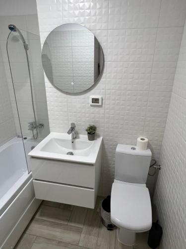 a white bathroom with a sink and a mirror at Sunny Apartments Avanera Suceava in Suceava