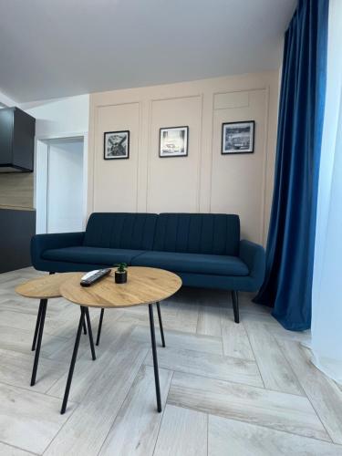 a living room with a blue couch and a table at Sunny Apartments Avanera Suceava in Suceava