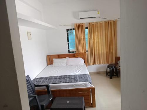 a small bedroom with a bed and a window at MALANAD GUEST HOUSE THENGIPALAM CHENAKAL UNIVERCITY ROAD 