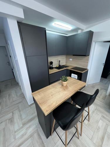 a kitchen with a wooden table and two chairs at Sunny Apartments Avanera Suceava in Suceava