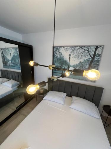 a bedroom with a large white bed and a window at Sunny Apartments Avanera Suceava in Suceava